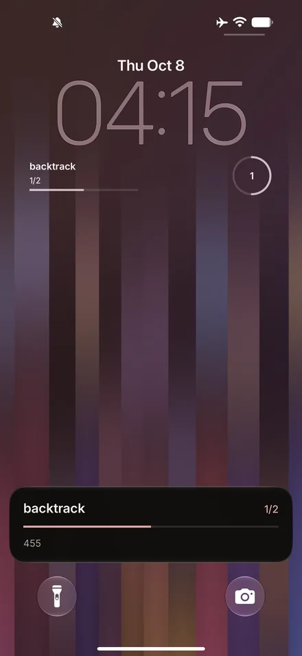 The iPhone Lock Screen with two Backtrack widgets under the clock, rectangular and circular, and a Live Activity at the foot showing 1/2 and the next step.